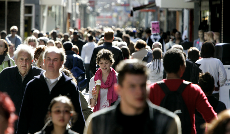 Busy street with people walking towards the camera