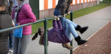 2 Kinderen spelen buiten en doen een koprol om een paal